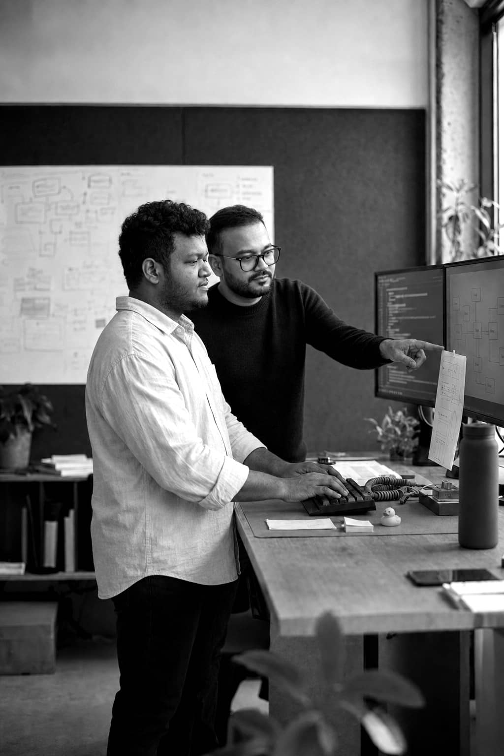 Black-and-white photo of engineers implementing a platform across multiple screens